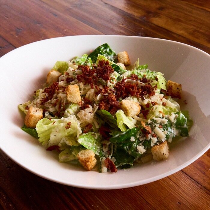 Caesar salad with romaine, house-made croutons, shaved parmesan and bacon bits