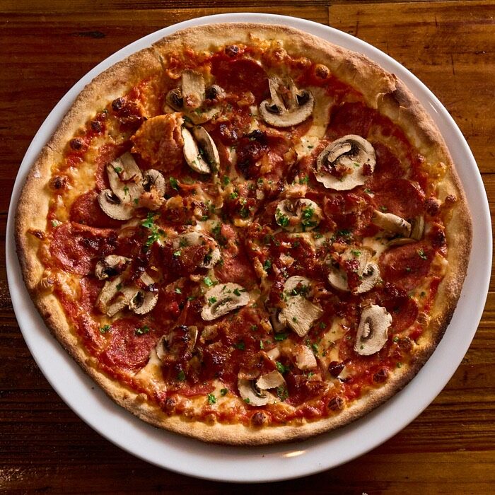 Canadian pizza topped with pepperoni, bacon and mushrooms