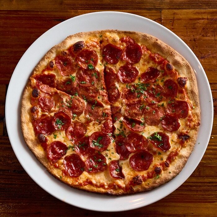 Double pepperoni pizza covered edge to edge with pepperoni and mozzarella