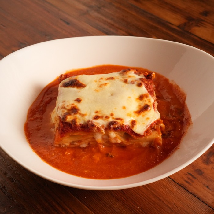 Mom's lasagna baked golden and served in tomato sauce