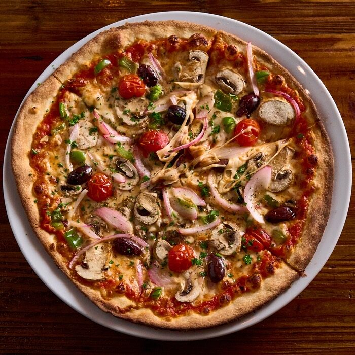 Veggie supreme pizza with green peppers, mushrooms, cherry tomatoes, red onion and olives