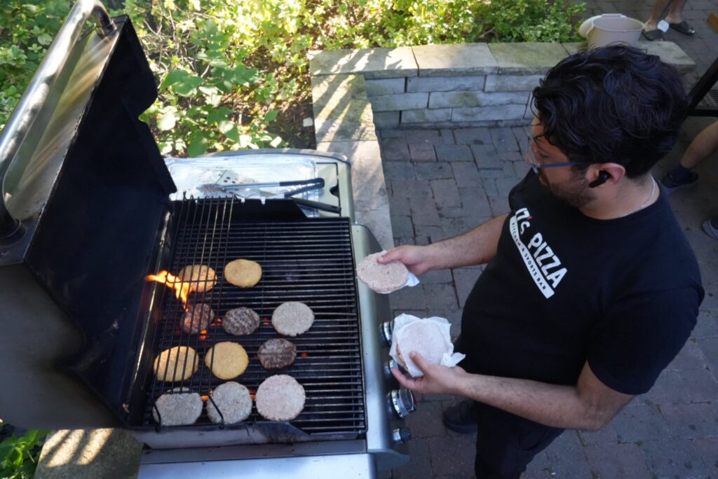 Sina from JZ’s Pizza grilling burgers and veggie patties at a condo building BBQ