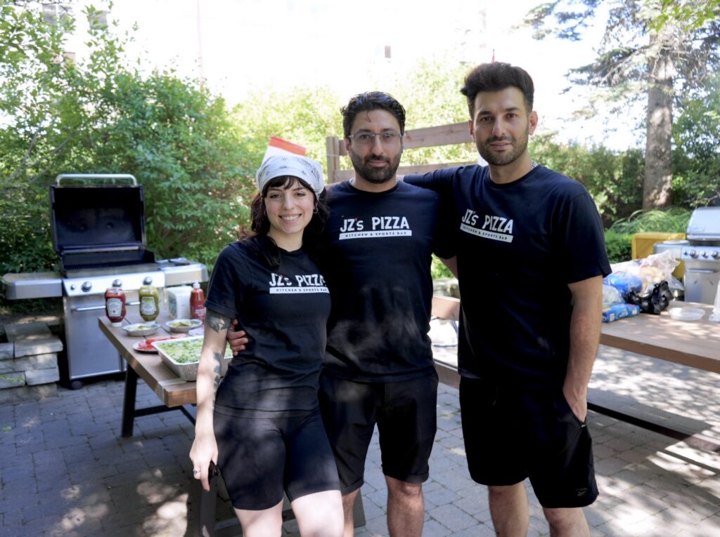 Three members of the JZ’s Pizza team in JZ’s T-shirts at an outdoor BBQ